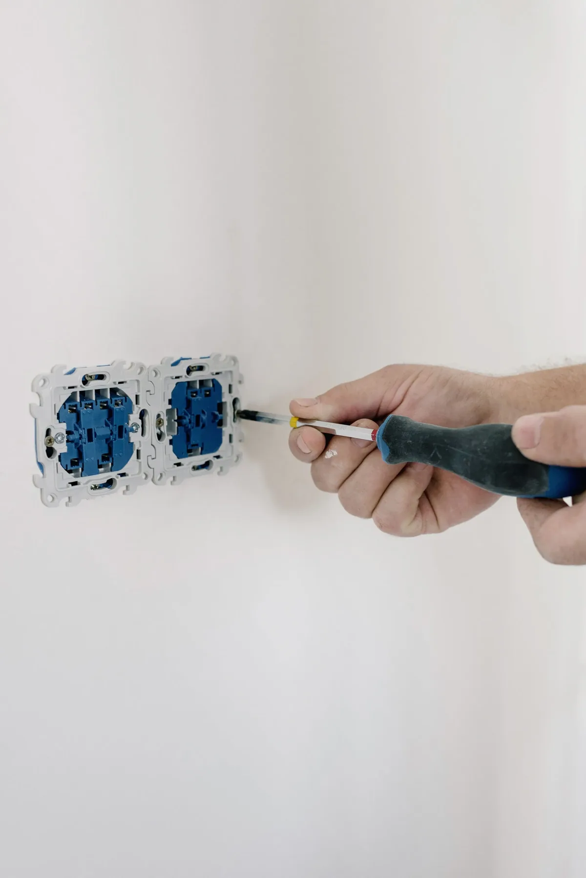 Eletricista retirando uma tomada da parede com cuidado