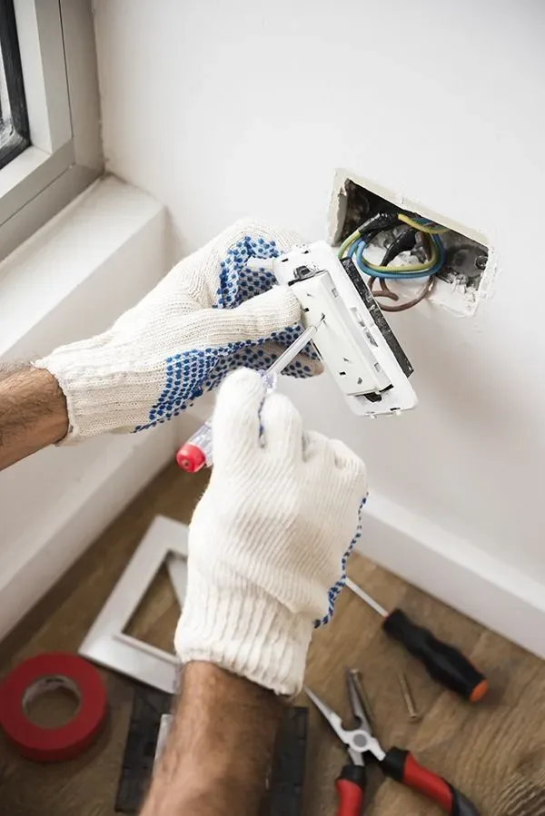 Eletricista instalando uma nova tomada em uma parede